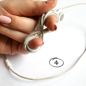 Zeigefinger und kleiner Finger beenden das Aufwickeln des Kopfhörer-Kabel