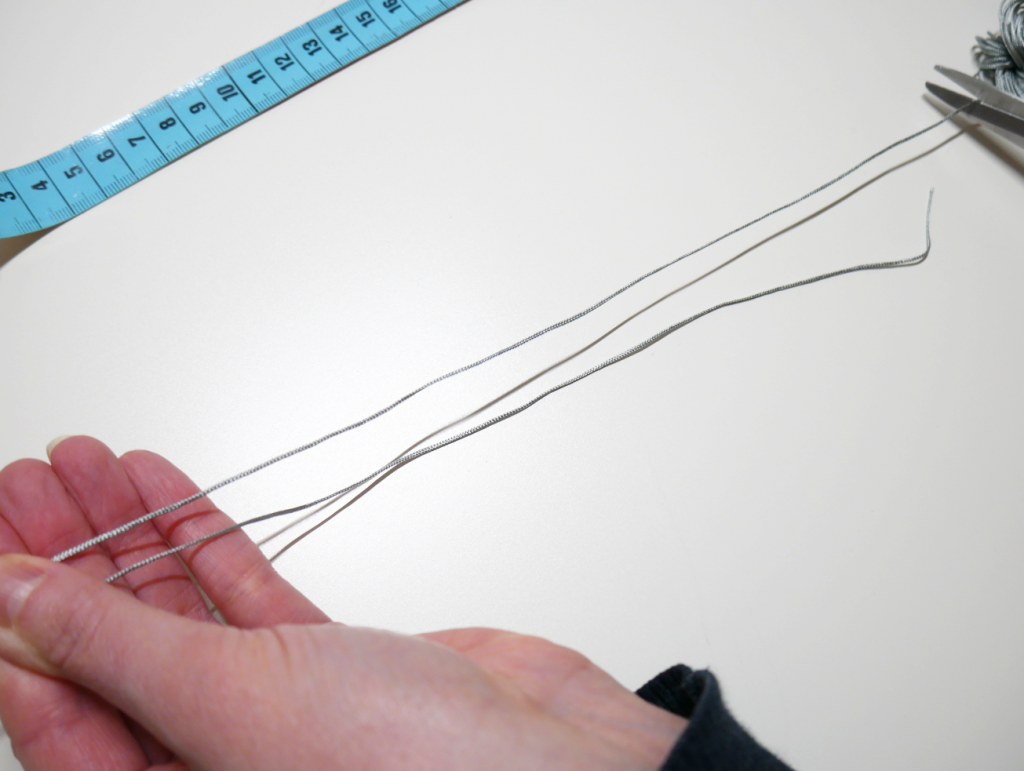 Den zweiten Faden mit Schere abschneiden