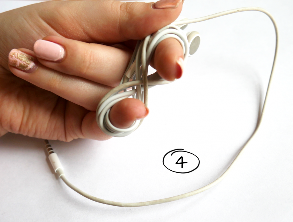 Zeigefinger und kleiner Finger beenden das Aufwickeln des Kopfhörer-Kabel