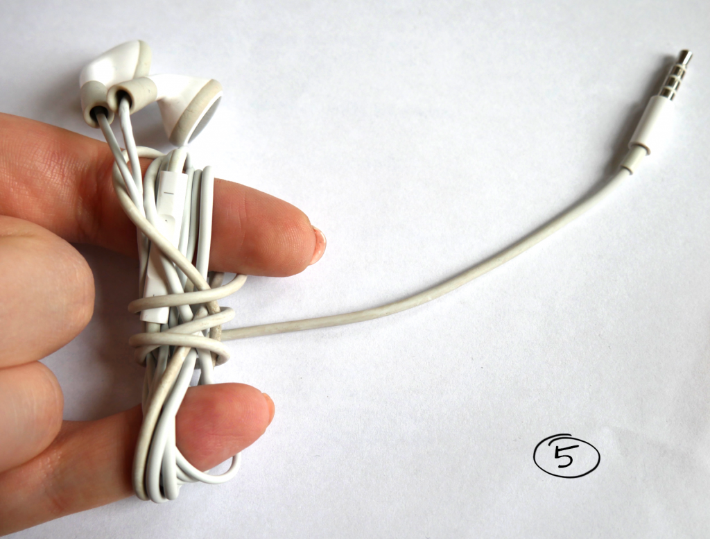 Kopfhörer Kabelende mit Anschluss wird um aufgewickelte Kopfhörer gewickelt