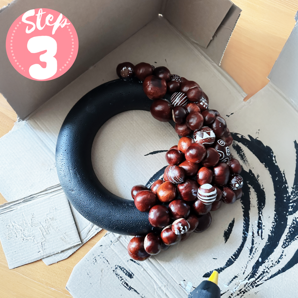 Schwarzer Styropor-Ring mit beklebten Kastanien